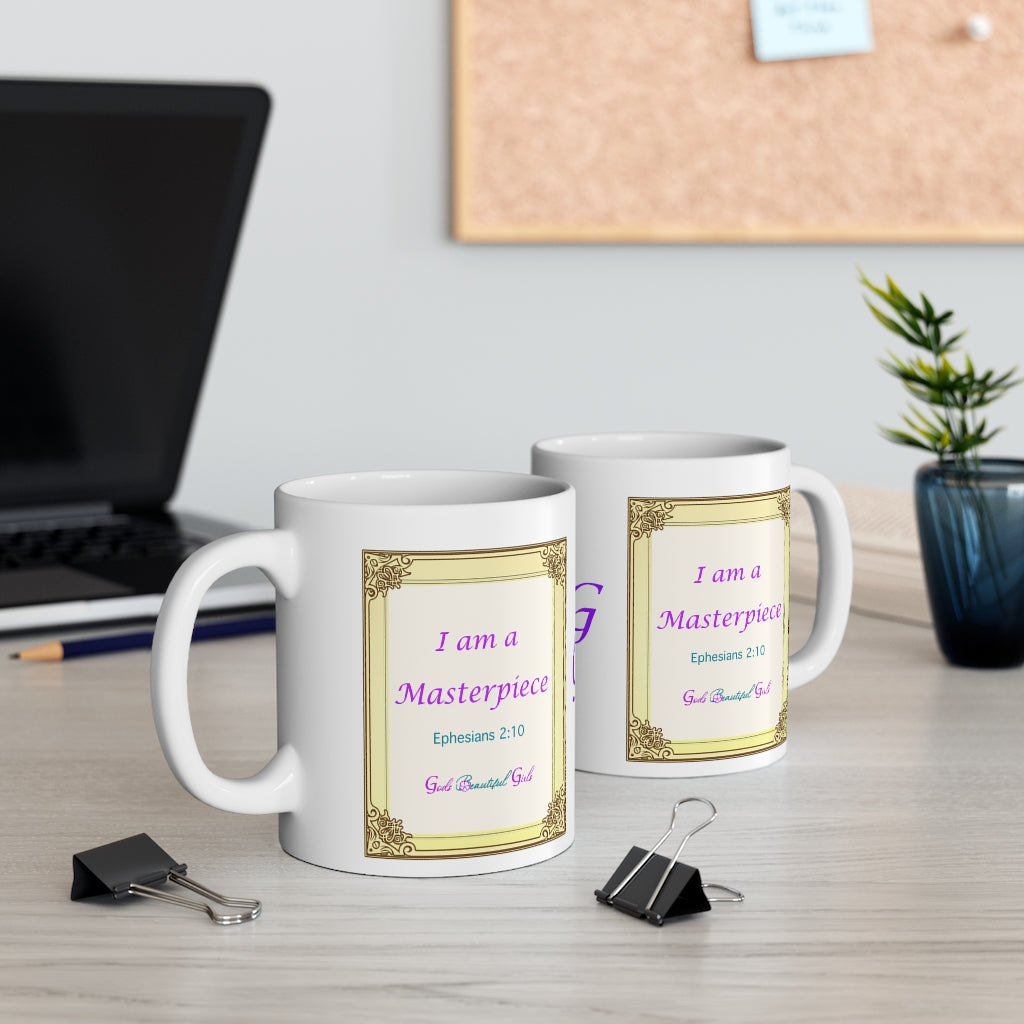 Two white coffee mugs on desk with the words "I am a Masterpiece Ephesians 2:10 God's Beautiful Girls" in purple and turquoise letters inside a gold frame for a painting, on the front and back of mugs. 
